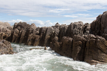 Seascape with rocks and blue sea in a sunny day, near Mangawhai Heads, Auckland, New Zealand.