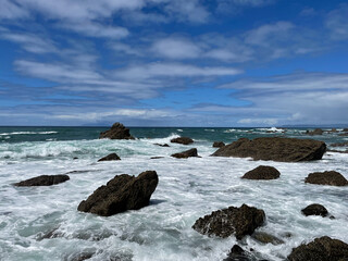 Marine landscape. Rocks and sea waves in a sunny day. Mangawhai Cliff Walk, New Zealand.