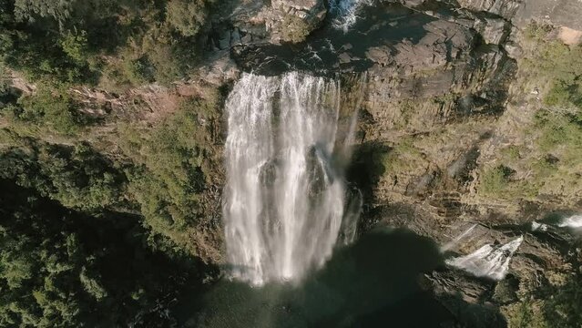 Drone scenic view of waterfall on mountain during sunny day