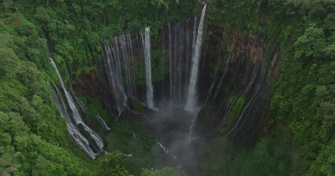 Aerial Panning Shot Of Water Flowing On Rock Formations In Forest - Java, Indonesia