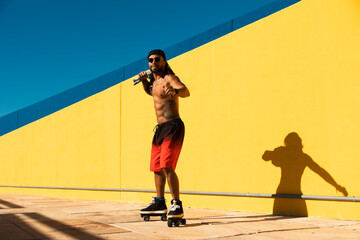 Black man on roller skates riding outside. Urban man posing with roller skates..