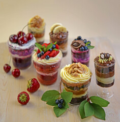 Homemade desserts in glass jars. Traditional unbaked Italian dessert on a white background. Cake with coffee, berries, fruits and mascarpone cream.
