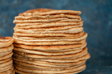 Flatbread lavash, chapati, naan, heap of tortilla on a blue background Homemade flatbread stacked.