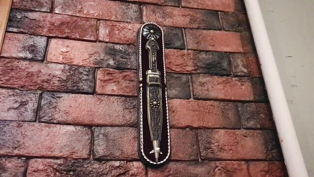 Dagger kama Georgian blade edged weapon, antique, one object, beautiful ornate, hanging on the wall exhibit of the restaurant museum.concept weapon of the world.