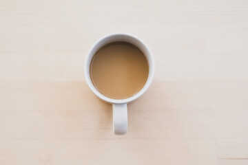 White cup of hot coffee on wooden table, soft focus.