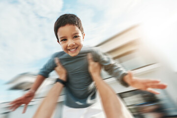 Family, speed and portrait of boy in air enjoying playing outdoors on holiday, vacation and...