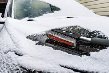 Cleaning black car from snow.