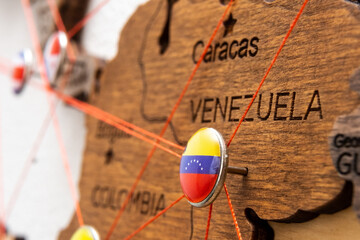 Venezuela flag pins and red thread for traveling and planning trips. Planning of logistics routes or spheres of influence in geopolitics