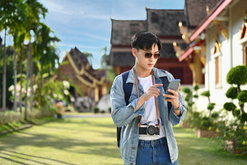 Young asian male tourist using smartphone platform applications for helping tourism about travel map GPS