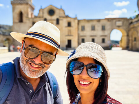 Indian ethnicity couple taking a selfie on vacation in the Italian town of Matera.
