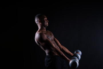 Portrait of a happy african man with dumbbells over red background