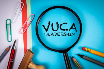 VUCA Leadership. Volatility Uncertainty Complexity Ambiguity. Magnifying glass on office desk