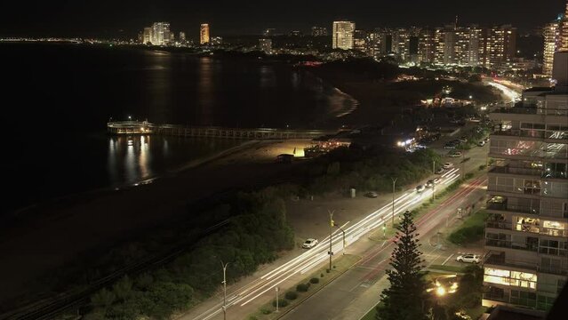 Time lapse shot of traffic on coastal road at night in Punta del Este City,Uruguay -. Aerial top down