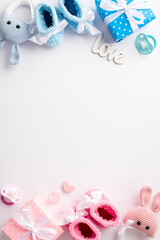 Gender reveal party concept. Top view vertical photo of pink and blue knitted booties gift boxes...