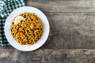 Traditional Spanish fideua. Noodle paella on wooden table. Top view. Copy space