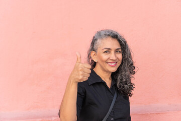 Gray-haired latina woman laughing while looking at the camera