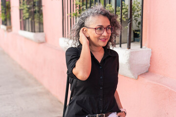 Modern older woman walking down the street