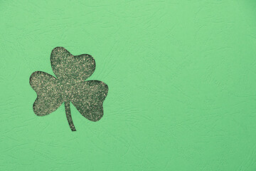 St. Patrick's day minimalistic concept. Clover leaf shape from textured paper and glitter...