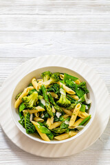 Pasta primavera with green veggies, cheese in bowl