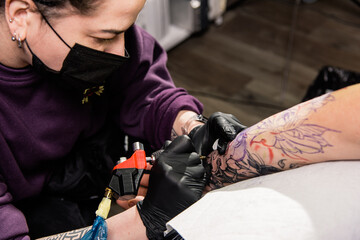 A tattoo artist makes a tattoo in a salon