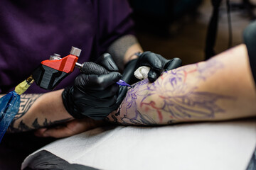 A tattoo artist makes a tattoo in a salon