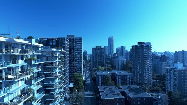 4k drone reveal Davie Street Broughton Bute Stunning Reflective New Condo buildings with Mirabel Marcon rooftop modern outdoor lounge gardens overlooking architectural marvel transformation blue sky