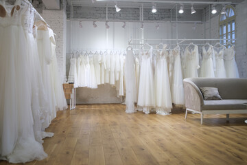 Different wedding dresses on hangers in boutique