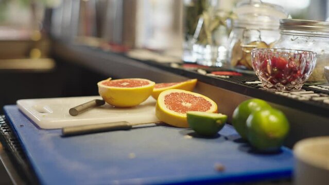 chopped up oranges and limes on a cutting board in a bar
