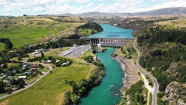 Blue river of New Zealand with small town and concrete dam, aerial view