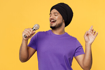 Singer devotee Sikh Indian man ties traditional turban dastar wear purple t-shirt sing song in...