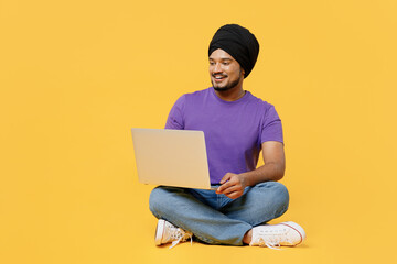 Full body smiling happy student devotee Sikh Indian IT man ties his traditional turban dastar wear...