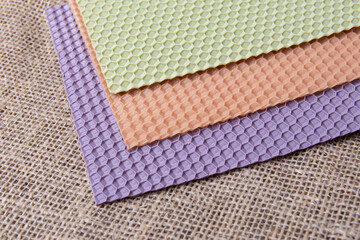 Fototapeta premium Colored wax sheets for candle making on burlap background. Soft focus