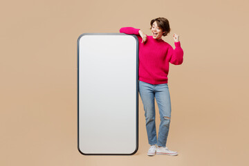 Full body young fun woman wear pink sweater big huge blank screen mobile cell phone smartphone with...