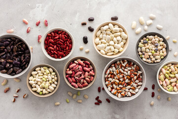 Obraz na płótnie Canvas Different types of beans in bowls, economically important legume, top view, copy space