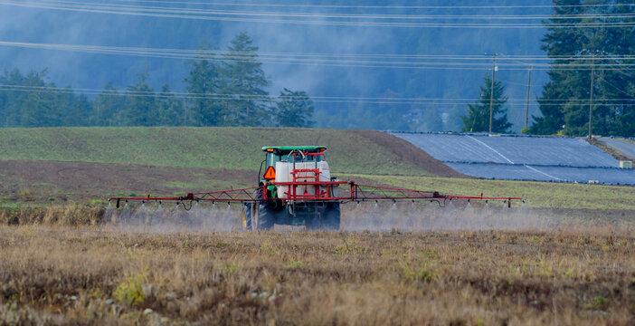Tractor Spraying a Field with fertilizer, Vancouver Island, British Columbia, Canada