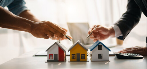 Salesman Hands On House Model , Small Toy House Small Mortgage Property insurance and concepts real estate.