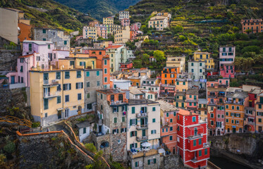 Fototapeta na wymiar Riomaggiore, Italy - September 2022: The colorful fishing village of Riomaggiore, Italy, one of the five Cinque Terre Villages along the Ligurian Sea. Aerial drone shot