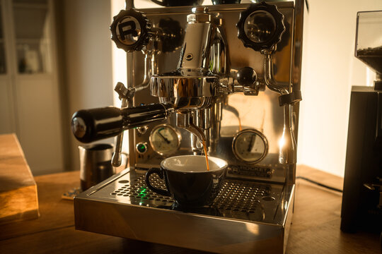 Barista Pouring Freshly Brewed Espresso In The Morning Sun At Home With Coffee Maker Machine