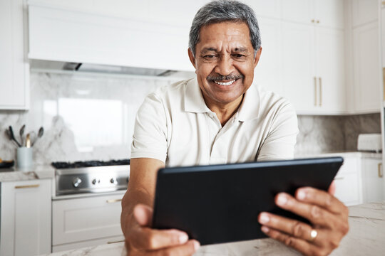 Mature man, tablet and home on social media, internet and reading online news application. Happy grandpa, digital technology and connection in house for networking, website search and ebook for smile