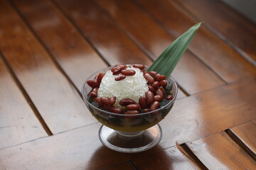  a cold drink made from red beans boiled with brown sugar served with coconut milk, shaved ice and covered with sweetened condensed milk chocolate and syrup. Indonesian drink.