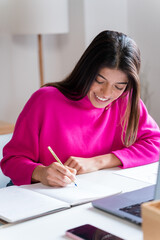 Smiling woman writing in notepad