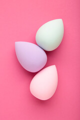 Beauty blender on pink background. Bright sponges for make-up cosmetics.