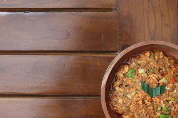 a close up smashed fruit which is made from raw fruit crushed in a mortar and pestle and added with shrimp paste, chili and brown sugar. In Indonesia it is called Rujak Bebek