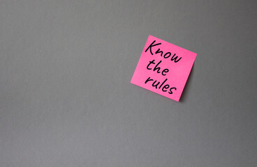 Know the rules symbol. Concept words Know the rules om pink steaky note. Beautiful grey background. Business and Know the rules concept. Copy space.