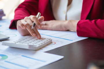 Marketing, Finance, Accounting, Planning, Portrait of a female accountant using a calculator and laptop to calculate balance using graphs for customers.