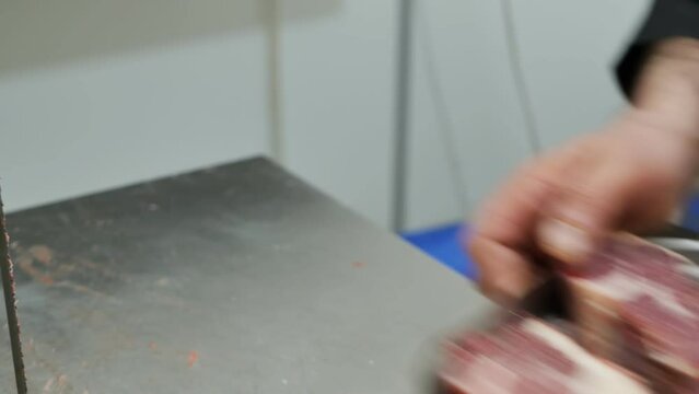 The butcher puts a lot of raw red beef steaks in a tray and takes them to the butcher shop for retail sale. Large chunks of fresh beef. Ramadan, Uraza, Halal