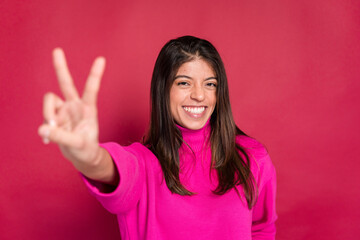 Cheerful woman showing victory sign