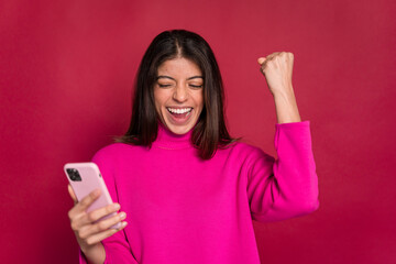 Excited woman with smartphone celebrating victory