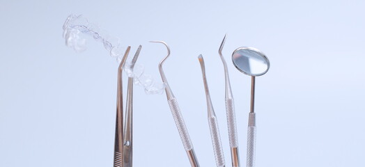 Dental tools and model of teeth on a blue background. Dental care concept. Invisible braces