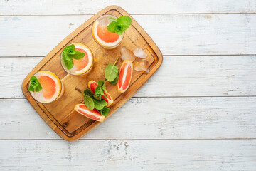 Summer refreshing fruit drinks with ice on a grey background. Flat lay, top view
